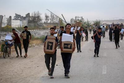 People carry relief supplies from the Gaza Humanitarian Foundation. AFP