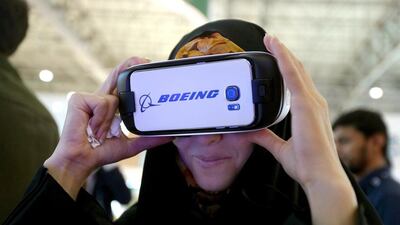 A visitor uses Boeing 3-D virtual reality goggles to look at the latest designs of Boeing planes at the Dubai Airshow. Marwan Naamani / AFP