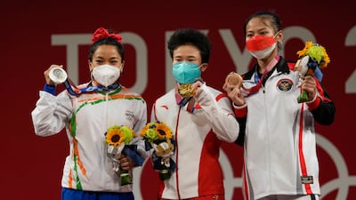 Gold medalist, Hou Zhihui of China, centre, stands with silver medalist Chanu Saikhom Mirabai of India, left, and bronze medalist Windy Cantica Aisah of Indonesia.