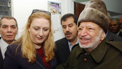 Palestinian leader Yasser Arafat is led out of his compound in the West Bank by his wife Suha Arafat to board a helicopter bound for France in 2004. PPO via Getty Images