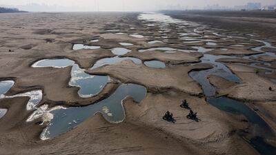 Scooter riders on a section of parched river bed along the Yangtze River in Hubei province, China. AFP