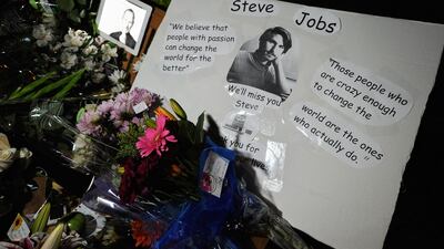 Flowers and an iPad showing a picture of Steve Jobs are placed at a makeshift memorial for Steve Jobs at the Apple headquarters on October 5, 2011 in Cupertino, California. Jobs passed away at age 56. (Kevork Djansezian/Getty Images/AFP)