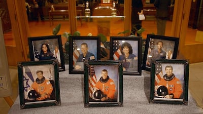 February 3 2003: Photos of the Space Shuttle Columbia adorn a table at the St. Paul The Apostle Catholic church in Houston, Texas during a memorial service in remembrance of the crew. The seven Columbia astronauts perished when the space shuttle orbiter d???