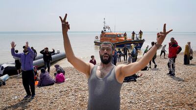 A man celebrates after arriving on the beach at Dungeness on July 19 before being taken away by Border Force staff. AP