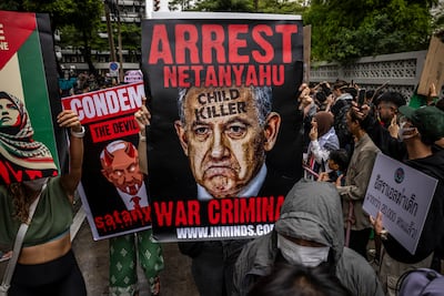 A protester holds a sign calling for the arrest of Israeli Prime Minister Benjamin Netanyahu during a demonstration outside the Israeli Embassy in Bangkok. Getty Images