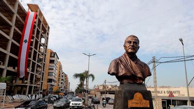 A Lebanese flag hangs from a building under construction behind the newly unveiled statue of Qassem Suleimani in the predominantly Shiite Beirut suburb of Ghobeiry. AFP