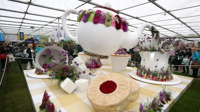 LONDON, ENGLAND - MAY 19: Visitors walk past a giant tea-pot on display on the first public day of the Chelsea Flower Show on May 19, 2015 in London, England. The show, which has run annually since 1913 in the grounds of the Royal Hospital Chelsea, is open to the public from 19 to 23 May and is expected to draw around 157,000 visitors. (Photo by Carl Court/Getty Images)