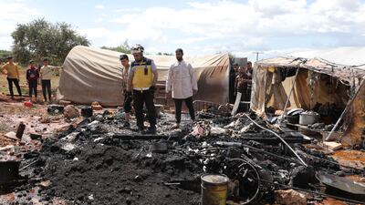 Syrians and rescuers survey the damage after an explosion at Harbanoush camp in Idlib, in May. EPA