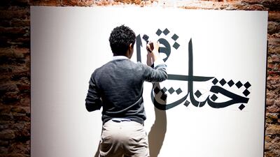 Nasser al Salem creates a work of calligraphy at 'Rhizomas: Generation in Waiting,' and exhibition of Young Artists from Saudi Arabia. Sofia Dadurian for The National
