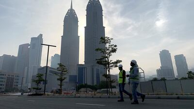 Construction workers wearing protective face mask in Dubai Internet City. Sites have remained operational during Covid-19, but measures have been taken to prevent its spread. Pawan Singh/The National