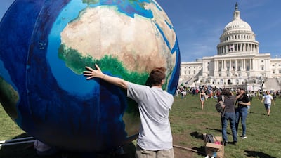 A youth touches an inflatable globe at the West Front of the US Capitol as crowds dispersed following the DC Climate Strike March in Washington, DC, USA. EPA