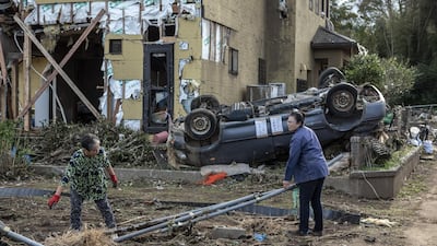 People recover items next to their house. Getty Images