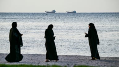 Women walk on a beach in Khasab, on northern Oman's Musandam Peninsula, which overlooks the Strait of Hormuz. AFP