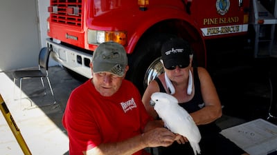 Mike Bailey and his wife Audrey with their cockatoo, Bailey, as they wait to be evacuated from Pine Island in Florida. Reuters