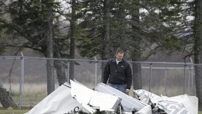 An FAA investigator examines the wreckage of a plane that crashed in Superior, Wisconsin after a mid-air collision with another plane. Steve Kuchera / The News-Tribune via AP