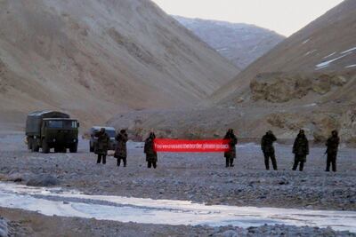 Chinese troops hold a banner which reads: "You've crossed the border, please go back" in Ladakh in May 2013. AP