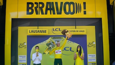 UAE Team Emirates Tadej Pogacar, wearing the overall leader's yellow jersey, celebrates on the podium after Stage 8. AP