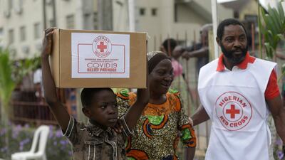 A child with his mother from Makoko Slum, carries their food parcel distributed by the Nigerian Red Cross, provided for those under coronavirus related movement restrictions, in Lagos, Nigeria. AP Photo