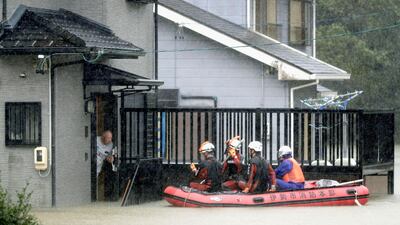 Rescuers on a boat patrol the residential area flooded by Typhoon Hagibis, in Ise, central Japan. AP