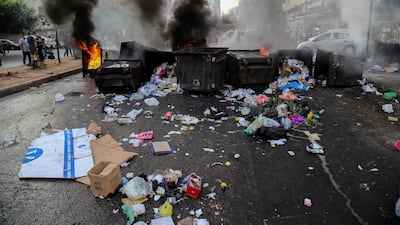Protesters block Beirut roads with bins and burning tyres.