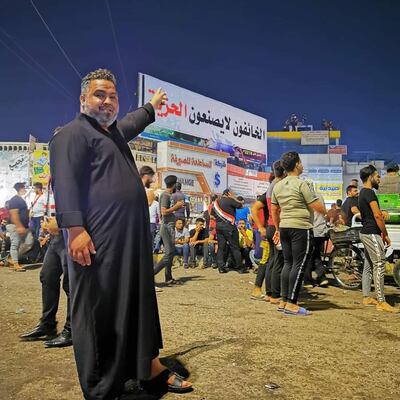 Slain Iraqi activist Ali Al Khafaji at an Iraqi demonstration in October 2019, pointing to a sign that reads "those who are afraid do not bring about freedom" . From Facebook
