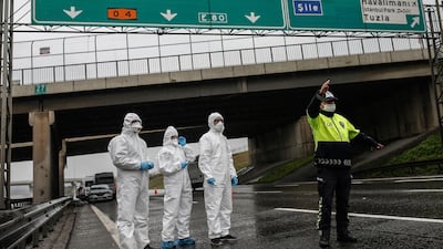 A police officer stops a bus so health officials could measure the body temperature of the passengers at a check point, on the Asian side of Istanbul. AP Photo