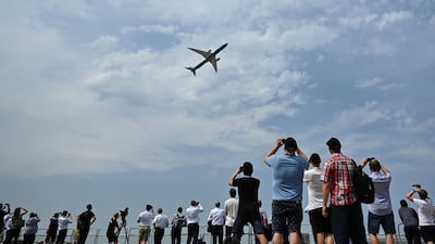 Vistors watch a plane take part in a display at Farnborough International Airshow. The UK government on Tuesday launched its Jet Zero strategy at the event. AFP