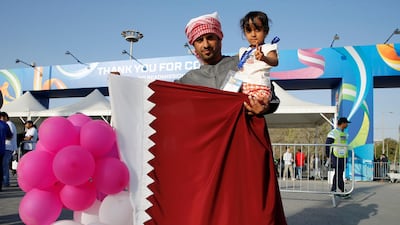 A Qatar supporter holds the country's flag before the AFC Asian Cup final against Japan at Zayed Sports City Stadium. Thaier Al Sudani / Reuters