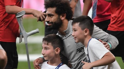 Mohamed Salah poses with children at the end of a training session ahead of the UEFA Super Cup 2019 match between Liverpool and Chelsea. AFP