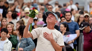A mourner with a floral tribute to Bondi Beach shooting victims arrives at the scene in Sydney, Australia to pay his respects, after 15 people were killed by father-and-son gunmen. AFP