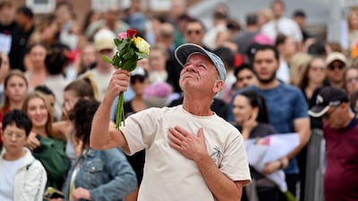 A mourner with a floral tribute to Bondi Beach shooting victims arrives at the scene in Sydney, Australia to pay his respects, after 15 people were killed by father-and-son gunmen. AFP