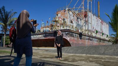 Visitors posing by the tsunami memorial in Banda Aceh. AFP