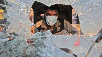 A tuktuk (motorised rickshaw) driver sits behind his broken windshield in his vehicle during clashes between anti-government protesters and security forces in the Iraqi capital Baghdad's Rasheed street near al-Ahrar bridge. AFP