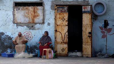 A Palestinian man repairs a fishing net outside his house at Al-Shati refugee camp, in Gaza City. REUTERS/Mohammed Salem/File Photo