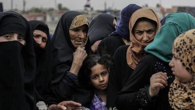 Mosul residents wait at a food distribution point inside western Mosul, Iraq. . (AP Photo/Bram Janssen, File)