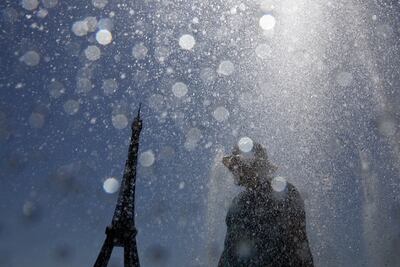 A tourist cools off in the Trocadero Fountain next to the Eiffel Tower, which was closed as a result of the heat in Paris on Wednesday. Reuters