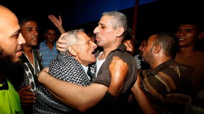 Freed Palestinian prisoner Ateya Abu Moussa, who was held by Israel for 20 years, hugs his father. REUTERS / Ibraheem Abu Mustafa