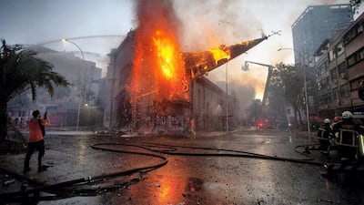The dome of the church of Asuncion falls down burning in flames after being set on fire by demonstrators in Santiago. AFP