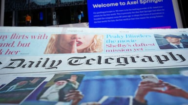 Daily Telegraph laid by the home page of German media group Axel Springer on a laptop. Yui Mok/PA Wire