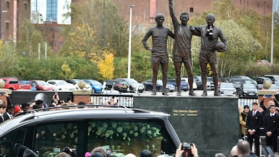 The cortege of English soccer icon Bobby Charlton passes by the statue of Manchester United trio of George Best, left, Denis Law, center, and Sir Bobby Charlton outside Old Trafford stadium on its way to the funeral service at Manchester Cathedral in Manchester, England, Monday, Nov. 13, 2023. Charlton who played largely for Manchester United survived a plane crash that decimated a United team destined for greatness, he went on to became the heartbeat of his country's 1966 World Cup triumph. (AP Photo / Rui Vieira)
