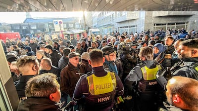 Policemen and concerned bank customers gather in front of a branch of the Sparkasse bank in Gelsenkirchen, western Germany, after the bank was robbed. AFP