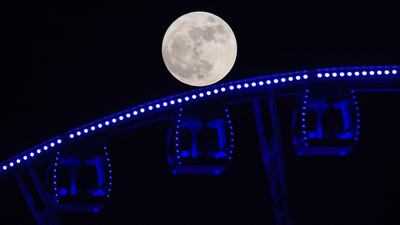 The supermoon rises behind a Ferris wheel in Hong Kong. Anthony Wallace / AFP Photo