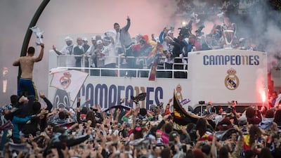 Real Madrid football club supporters celebrate as the team arrives on Plaza Cibeles in Madrid on May 29, 2016 after the UEFA Champions League final foobtall match between Real Madrid CF, Club Atletico de Madrid held in Milan, Italy. / AFP / PEDRO ARMESTRE