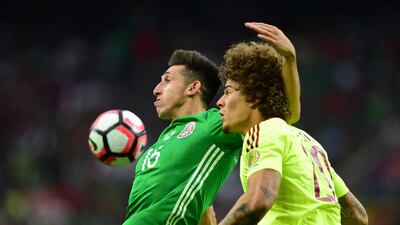 Mexico’s Hector Herrera, left, and Venezuela’s Rolf Feltscher vie for the ball. Alfredo Estrella / AFP