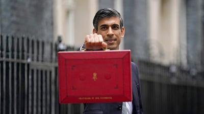 Britain's Chancellor of the Exchequer Rishi Sunak poses with the Budget box as he leaves No 11 Downing Street in London. The UK economy is set to grow 6.5 per cent this year but rising inflation poses a risk. PA