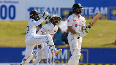 Sri Lanka's wicketkeeper Niroshan Dickwella (L) and teammate Dhananjaya de Silva celebrate after the dismissal of Pakistan's Mohammad Nawaz (R) during the second day of the second cricket Test match between Sri Lanka and Pakistan at the Galle International Cricket Stadium in Galle on July 25, 2022. (Photo by ISHARA S. KODIKARA / AFP)