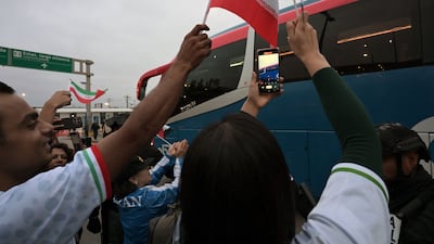 Football fans cheer as Iran's players leave the Tijuana International Airport on a bus. AFP