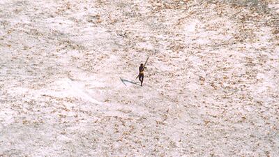 A Sentinel tribal man aims with his bow and arrow at an Indian Coast Guard helicopter as it flies over the island in India's Andaman and Nicobar archipelago, December 28, 2004. Reuters