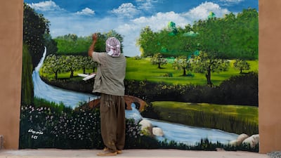 Artist Fares Bibani, 55, paints a colourful mural on the wall of a house in Beban village in Mosul, Iraq. All photos: Reuters