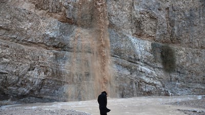 A person gathers to witness the first flash flood of the season surging through the Qumran riverbed in the Judean Desert, near the Dead Sea, West Bank, on a stormy day in the region. EPA
